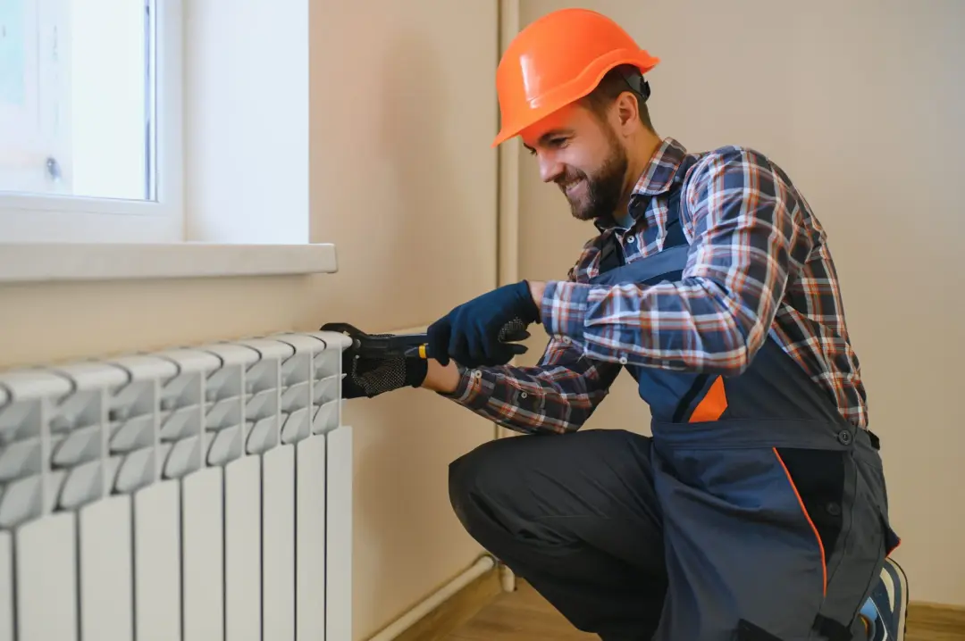 Plumber fitting a radiator