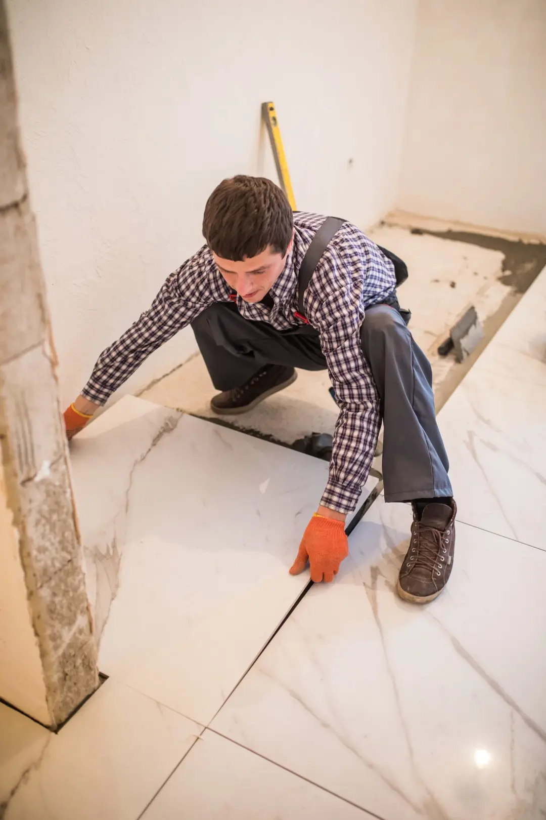 Tiler laying large floor tiles